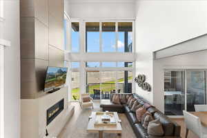 Living room featuring a fireplace, a high ceiling, and TV