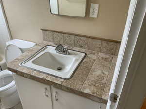 Half bathroom featuring toilet, mirror, and washbasin