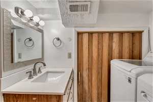 Basement bathroom with vanity, shower, toilet and laundry facilities