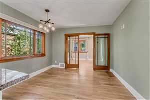 Spacious dining nook features large windows and hardwood flooring