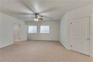 Empty room with a ceiling fan and carpet