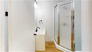 Unit 10 Bathroom with wood-type flooring, vanity, mirror, and enclosed shower