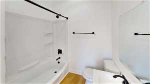Unit 2 Full bathroom featuring hardwood flooring, mirror, toilet, sink, and shower / bathtub combination
