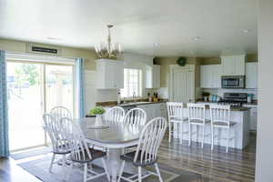 Dining room featuring wood-type flooring, a kitchen breakfast bar, natural light, and microwave