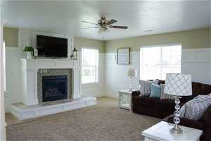 Living room with a fireplace, a ceiling fan, carpet, natural light, and TV