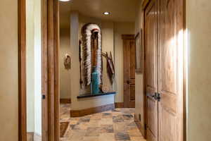 Hall with recessed lighting and stone finish flooring