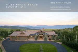 Rustic home with a chimney, curved driveway, an attached garage, and a mountain view