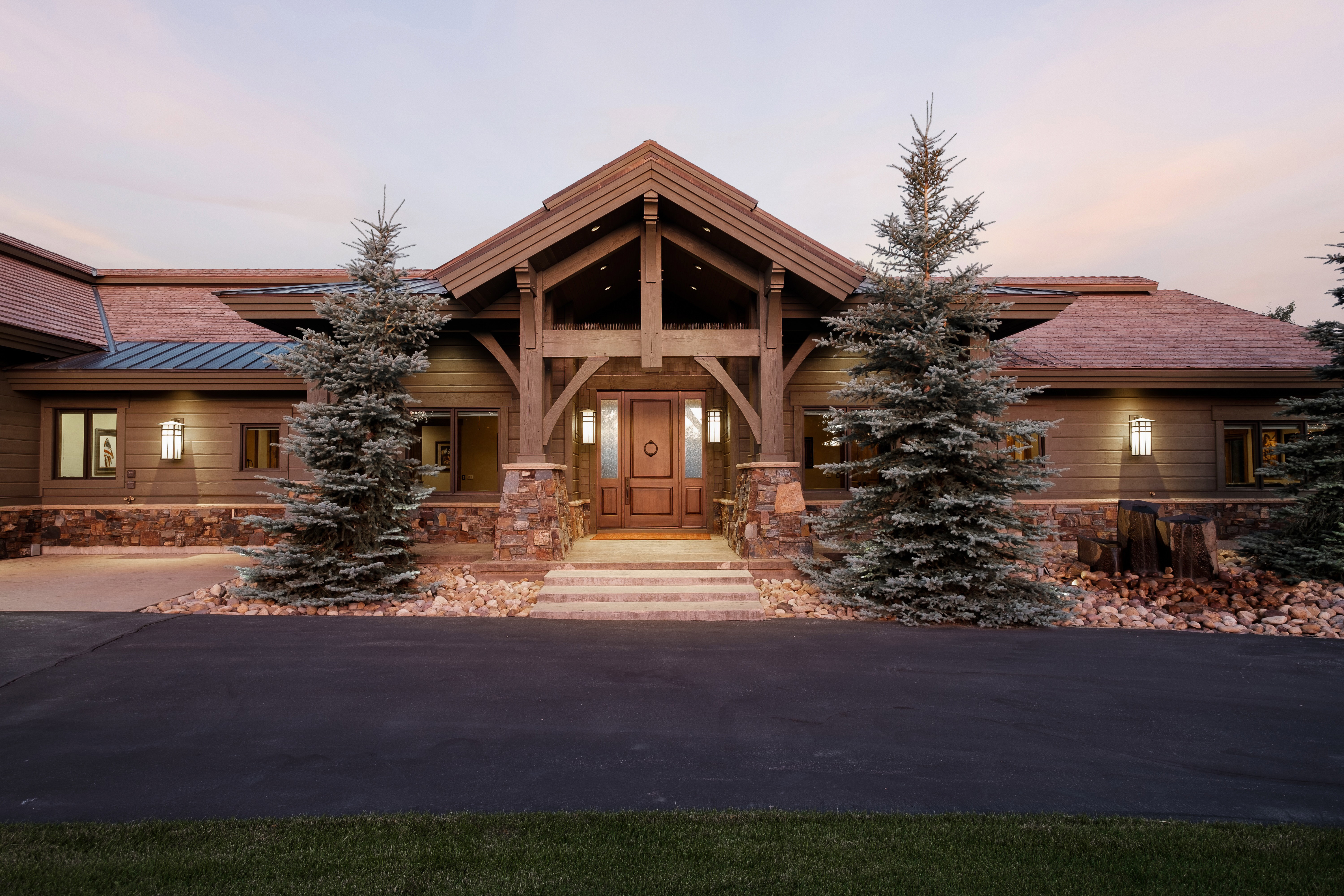 View of front facade with a standing seam roof, metal roof, and stone siding