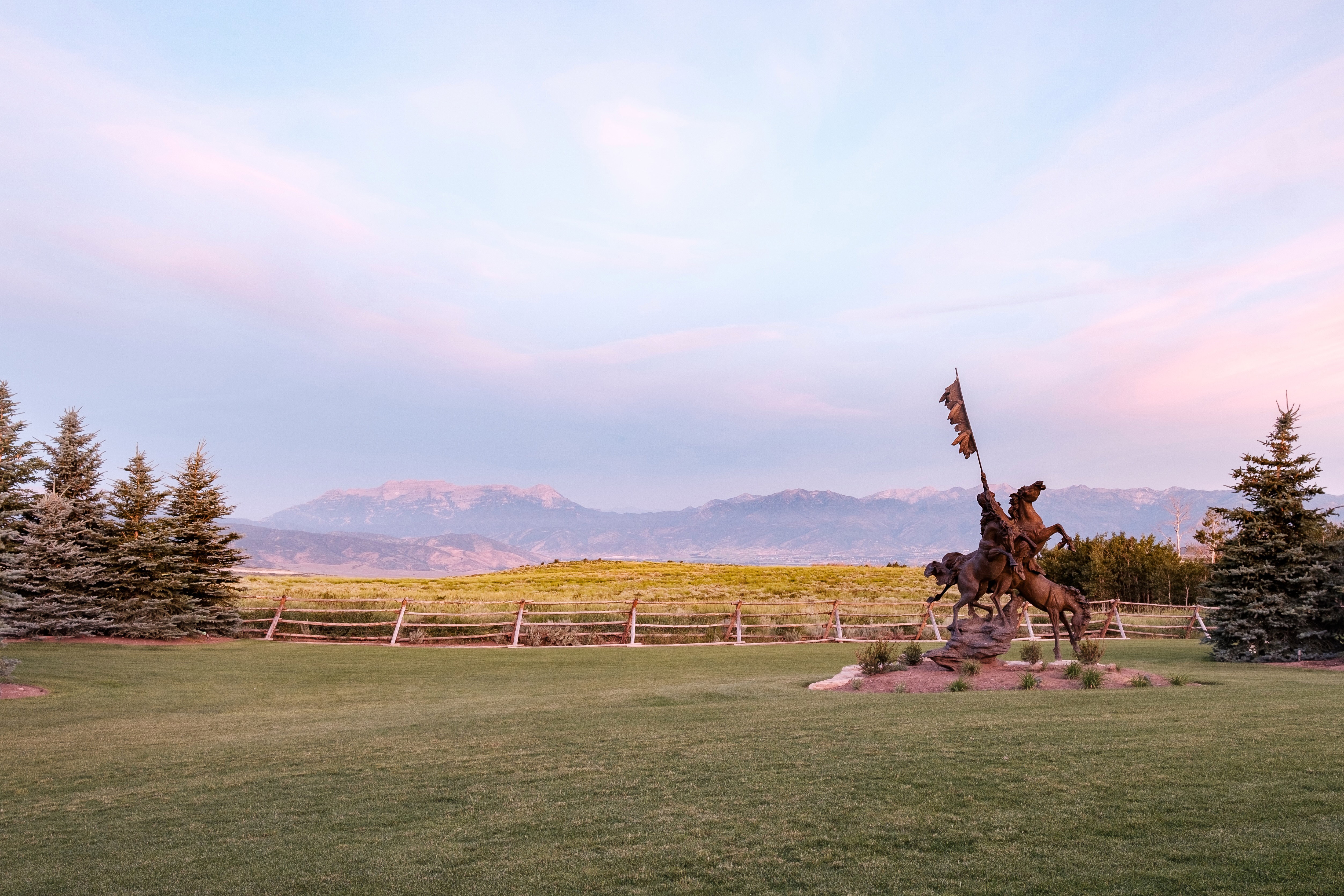 Yard at dusk with a mountain view, a rural view, and fence