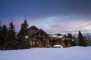 View of front of house with stone siding and covered porch