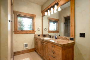 Bathroom with vanity, baseboards, and visible vents