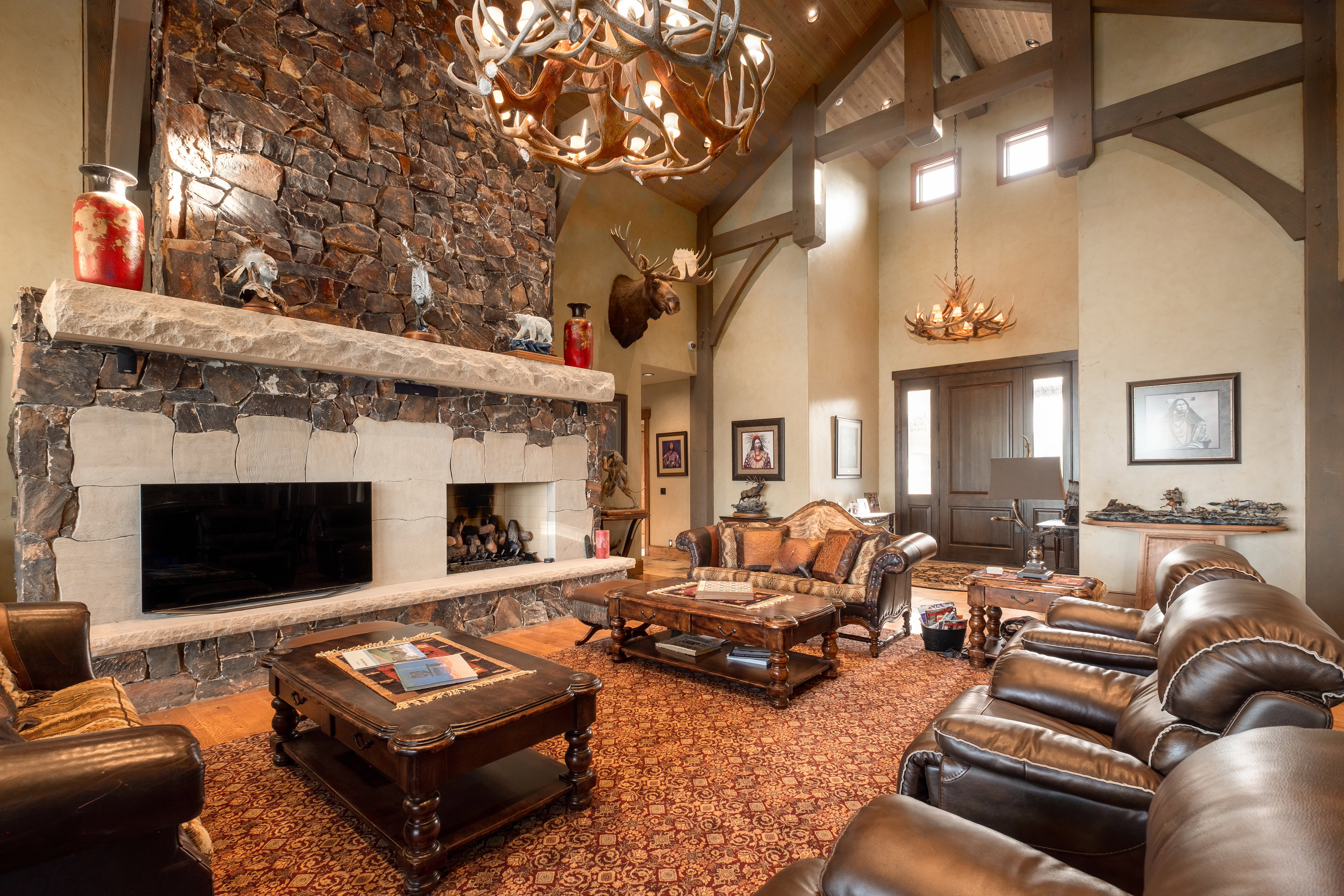 Living room featuring arched walkways, a fireplace, beam ceiling, high vaulted ceiling, and a notable chandelier