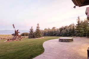 View of community featuring a lawn, a patio, and a mountain view