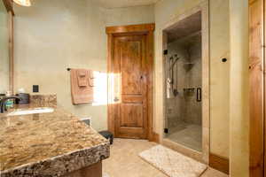 Full bathroom with vanity, a shower stall, and visible vents
