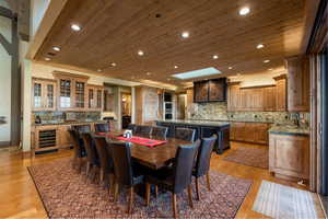 Dining space with recessed lighting, wine cooler, and wooden ceiling