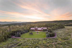 Birds eye view of property with a wooded view