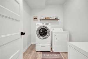 Laundry area with hardwood floors and separate washer and dryer
