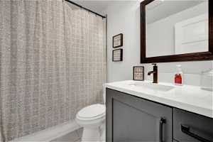 Bathroom with vanity, mirror, shower curtain, and toilet