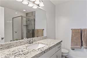 Master bath is a full bathroom with vanity, separate shower with glass door and bathtub, mirror, and toilet.