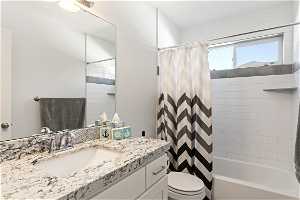 Full bathroom featuring vanity with extensive cabinet space.
