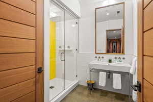 Bathroom featuring mirror, sink, and shower with glass door