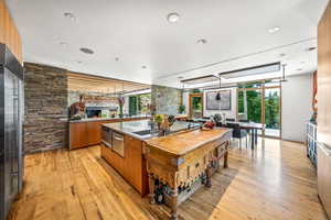 Kitchen with a center island, natural light, stainless steel finishes, light hardwood flooring, light countertops, and brown cabinetry