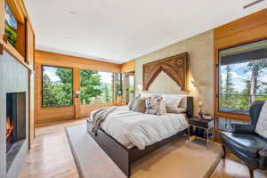 Bedroom featuring a fireplace, hardwood floors, and natural light