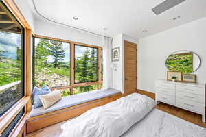 Hardwood floored bedroom with multiple windows