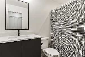 Bathroom with mirror, toilet, shower curtain, and vanity