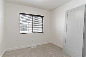 Carpeted empty room with natural light