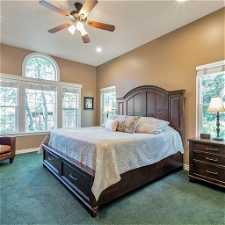Main Level Master Bedroom with multiple windows and a ceiling fan