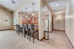 Kitchen with a kitchen island, light tile floors, appliances with stainless steel finishes, and pendant lighting