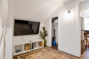 Living room with hardwood floors, lofted ceiling, and TV