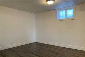 Hardwood floored empty room with a textured ceiling