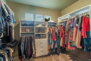 Walk in closet with dark carpet