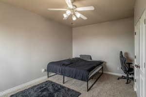 Carpeted bedroom featuring ceiling fan