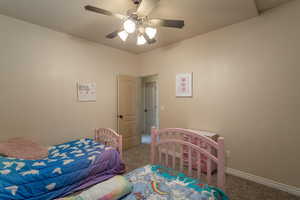 Carpeted bedroom featuring ceiling fan