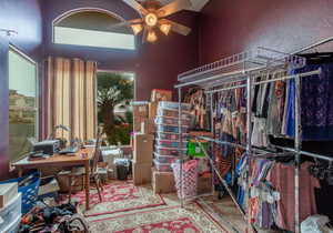 Walk in closet featuring ceiling fan and a high ceiling