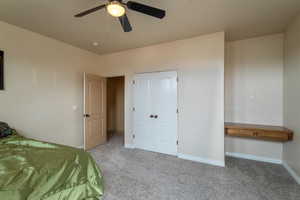 Bedroom with ceiling fan and light carpet