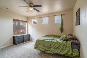 Carpeted bedroom featuring ceiling fan