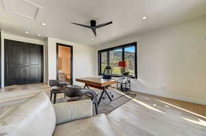 Living room with light hardwood / wood-style flooring and ceiling fan