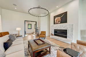 Living room with light hardwood / wood-style flooring and a high end fireplace