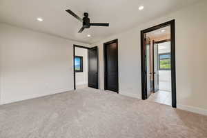 Unfurnished bedroom featuring ceiling fan and light colored carpet