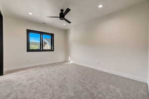 Unfurnished room featuring light colored carpet and ceiling fan