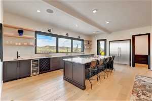 Kitchen with light hardwood / wood-style flooring, a wealth of natural light, and wine cooler