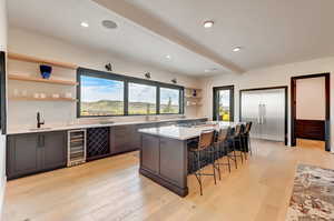 Kitchen with light hardwood / wood-style flooring, a wealth of natural light, and wine cooler