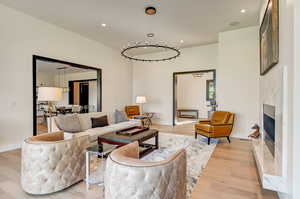 Living room with a high end fireplace and light wood-type flooring