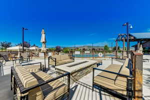 View of patio / terrace with a pool, an outdoor living space with a fire pit, and a gazebo