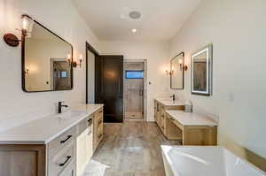 Bathroom featuring shower with separate bathtub, tile flooring, and dual vanity