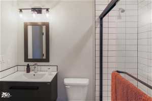 Bathroom with a tile shower, vanity with extensive cabinet space, and mirror